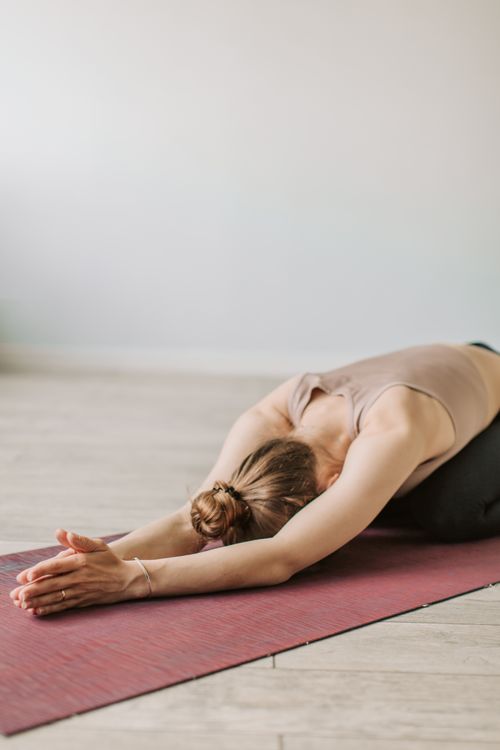 Woman doing a child's pose stretch on a yoga mat