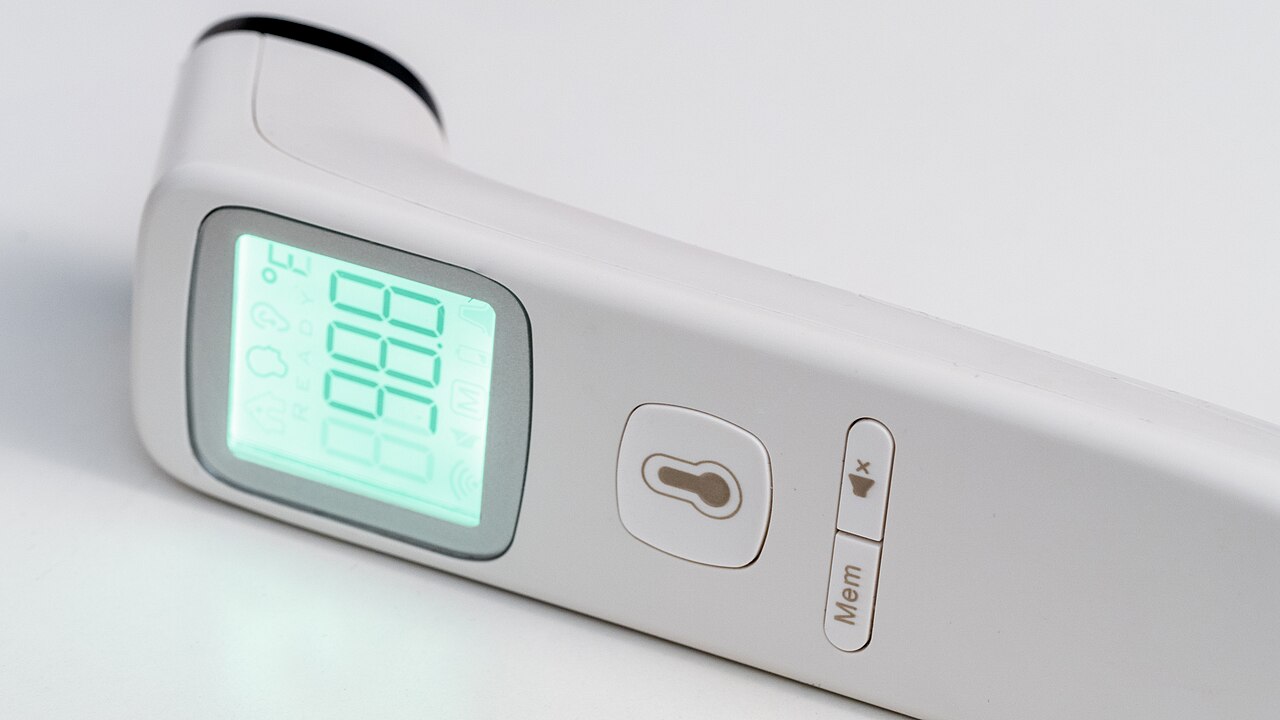 Digital thermometer showing a temperature reading, used to confirm a fever