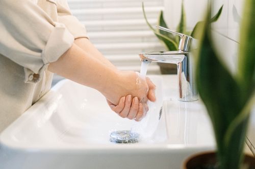 Person washing hands under running water
