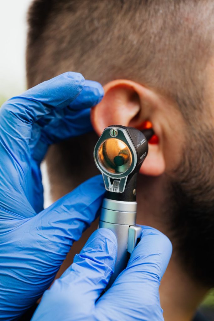 Doctor examining a patient's ear with an otoscope