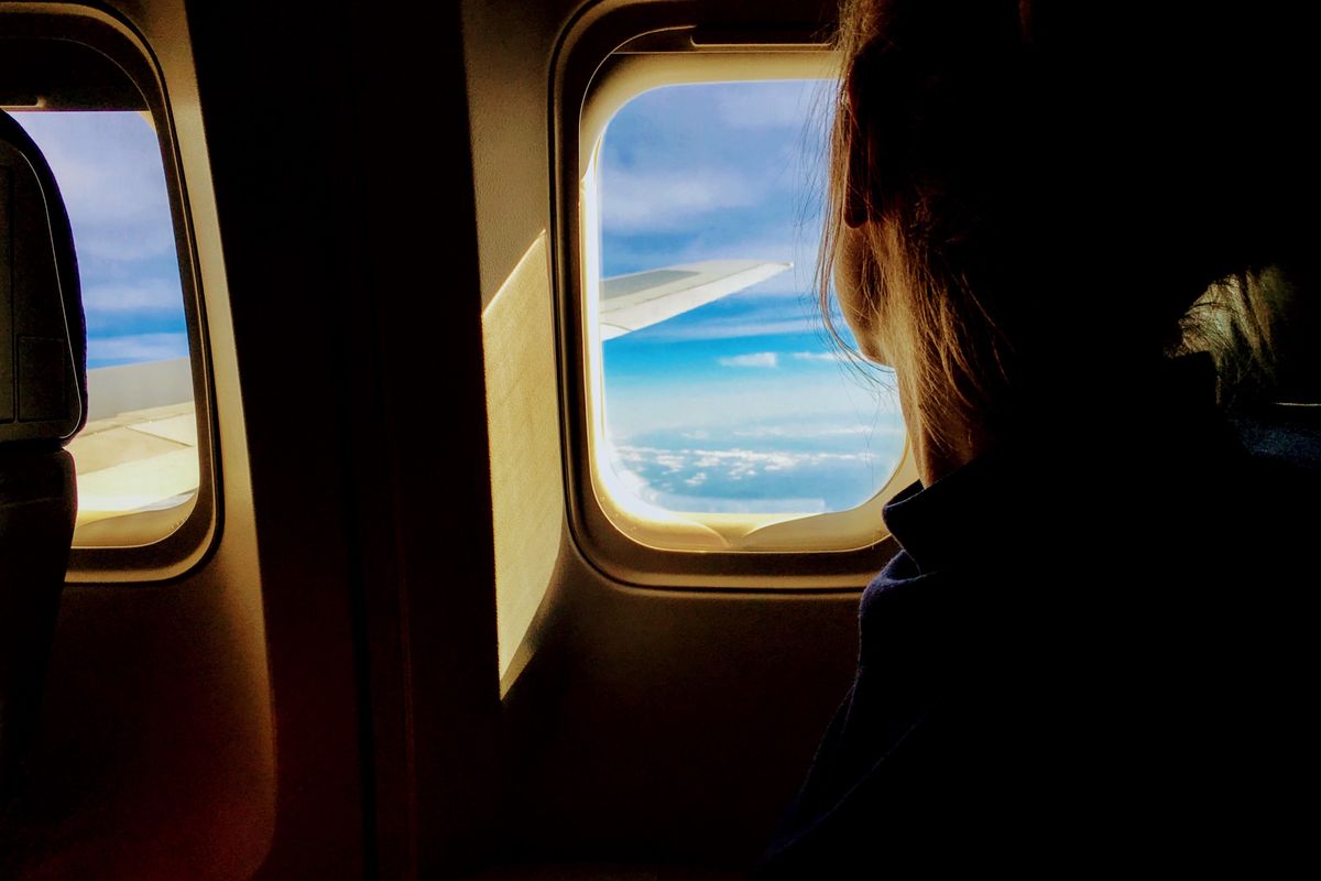 View through an airplane window above the clouds