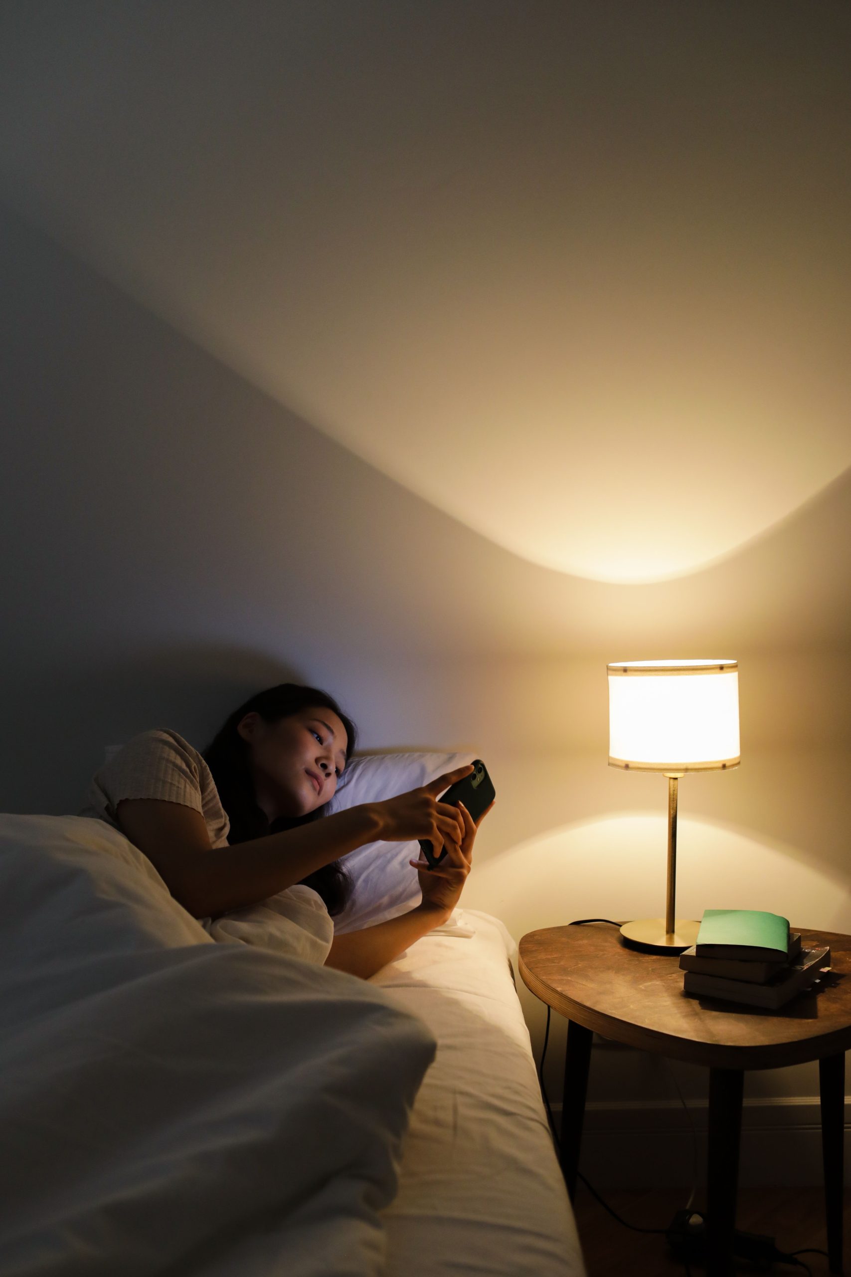 Woman awake in bed at night by a warm lamp