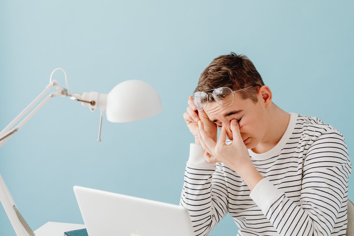 Person rubbing tired eyes after long screen use