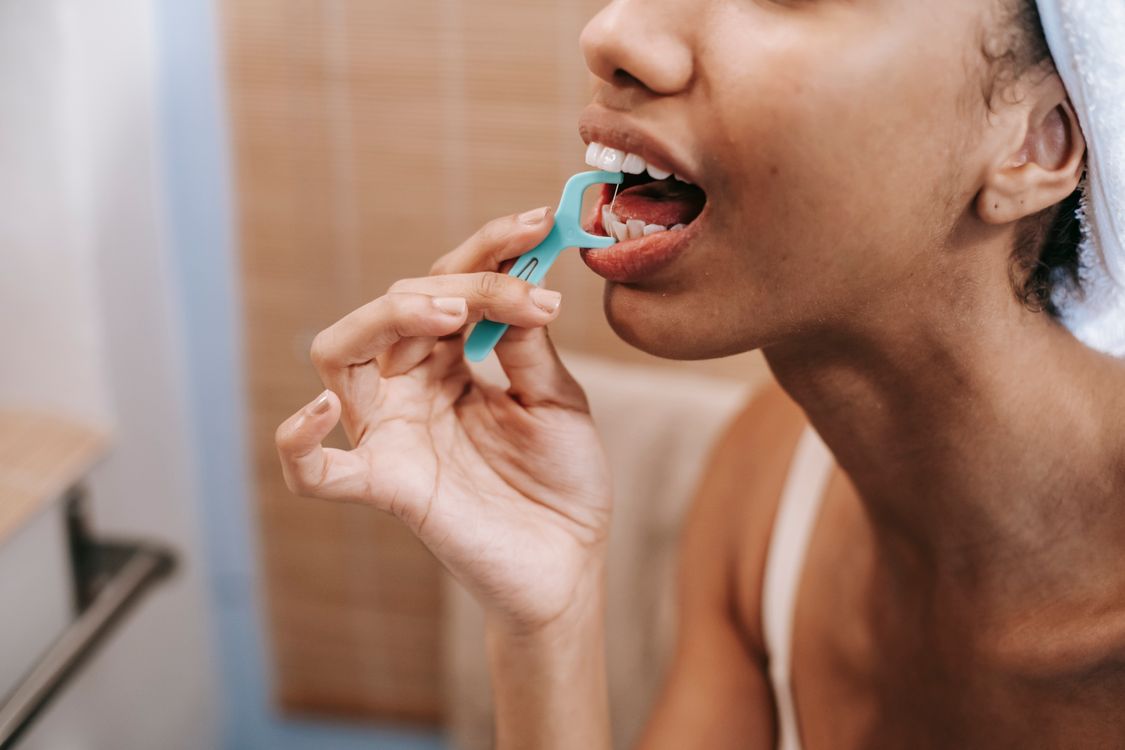 Cleaning between teeth with dental floss
