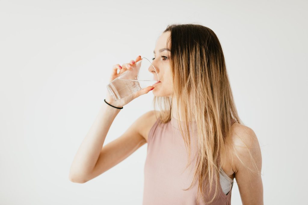 Young woman drinking a glass of cold water
