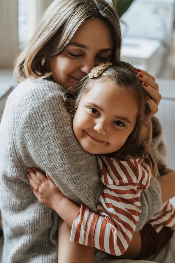 Mother comforting her young daughter, keeping her calm after she swallowed a small object. Photo: Pexels