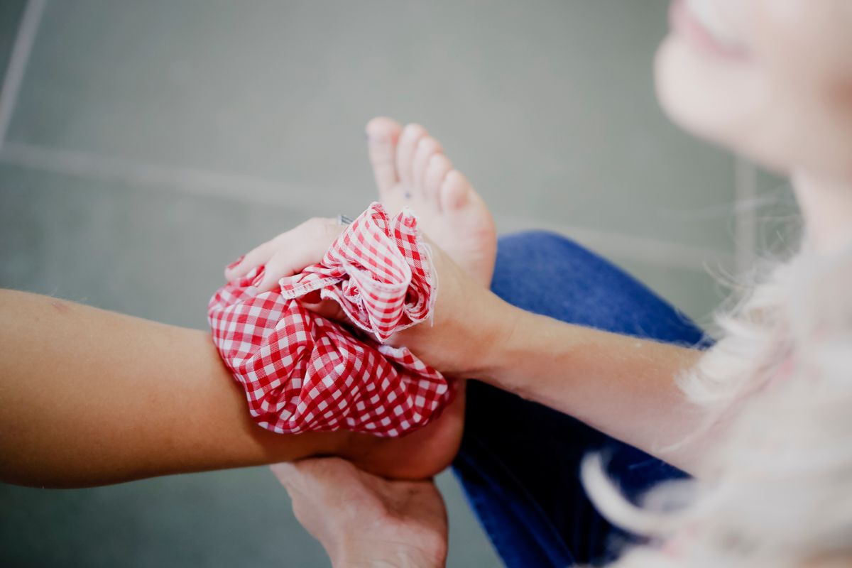 Applying an ice pack wrapped in a cloth to an injured hand — ice through cloth, 15 minutes at a time