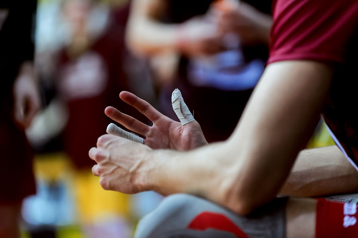 A thumb taped up after a sports finger injury — jammed fingers are common in basketball and cricket