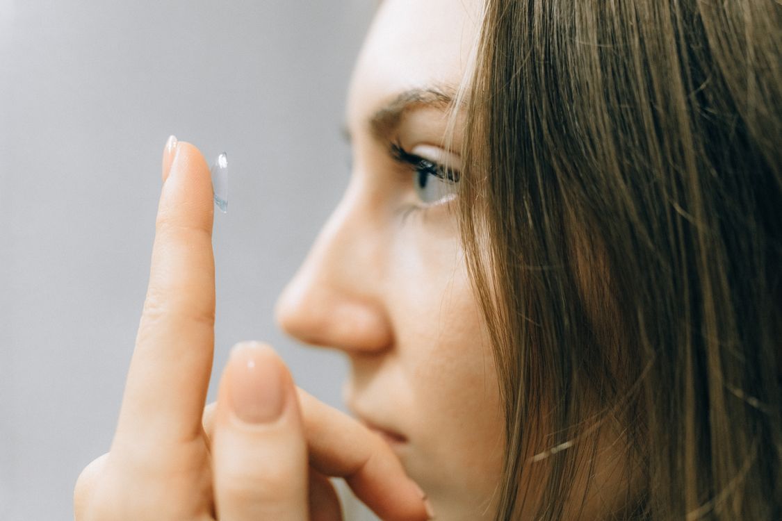 Woman applying a contact lens carefully