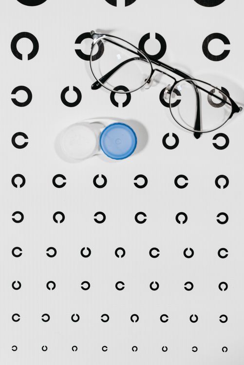 Eyeglasses and contact lens case on an eye test chart