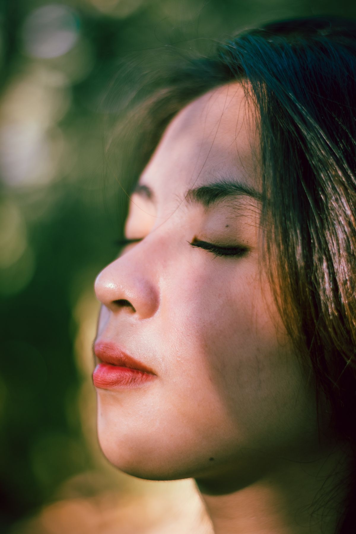 Woman with eyes closed, breathing deeply in fresh air