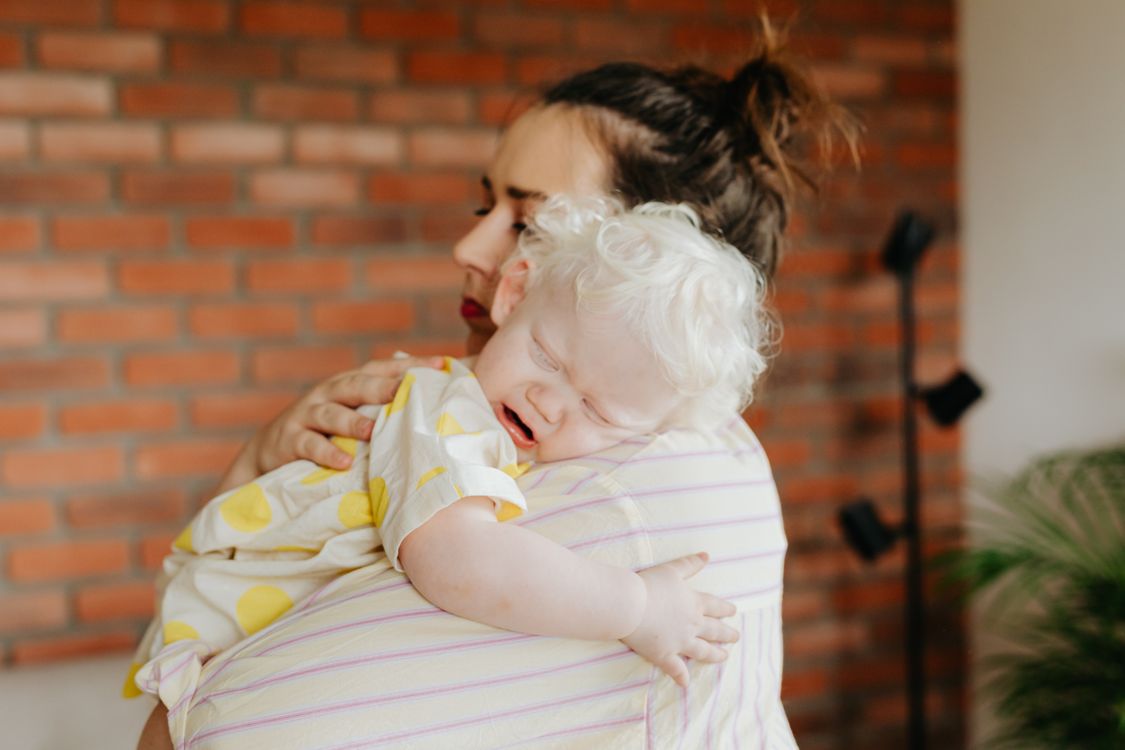 Mother holding and calming a crying toddler