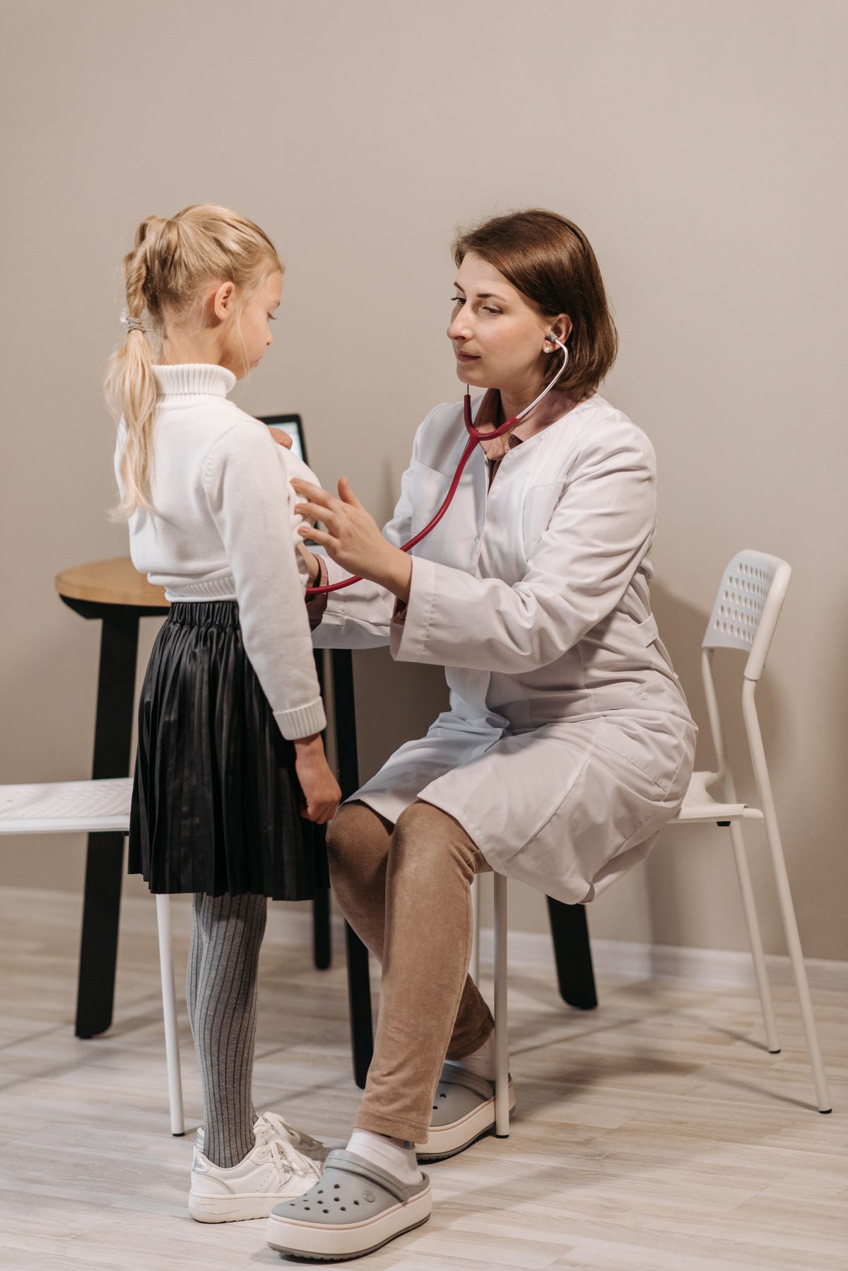 Pediatrician examining a young child in clinic