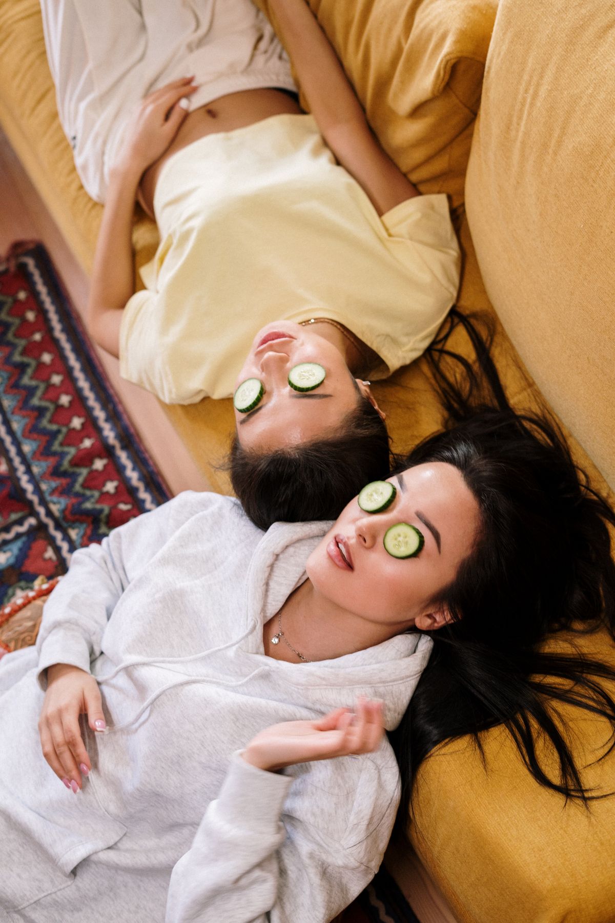 Two women relaxing with cucumber slices over their eyes