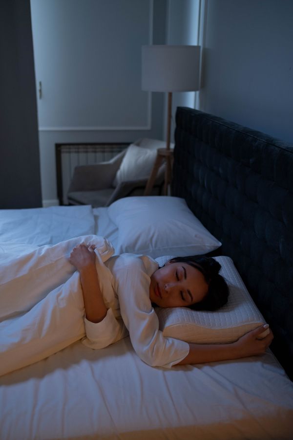 Person resting propped up on pillows in bed
