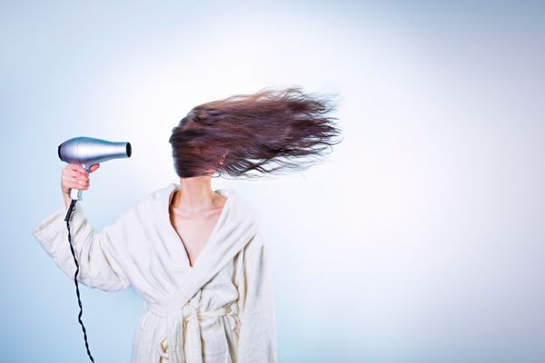 Woman drying with a hair dryer on the lowest warm setting